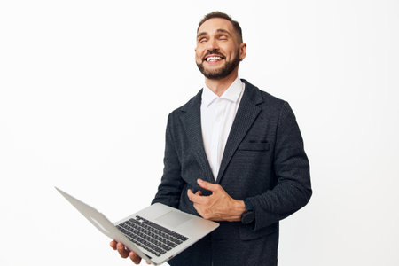 Business professional man on an isolated colored background, smiling with confidence while presenting a laptop, conveying motivation, energy, and approachable leadership.の写真素材