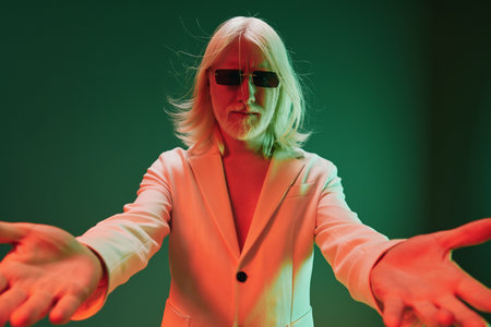 Fashion portrait of a stylish person in a suit with sunglasses against a colorful gradient background, exuding confidence and charisma Modern aesthetic, artistic expression, engaging compositionの写真素材