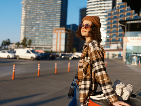 woman urban smile candid golden hour beanie sunglasses plaid portrait capturing authenticity and candid lifestyle with golden hour glow, mindful living mood and subtle emotional storytelling, modernの写真素材