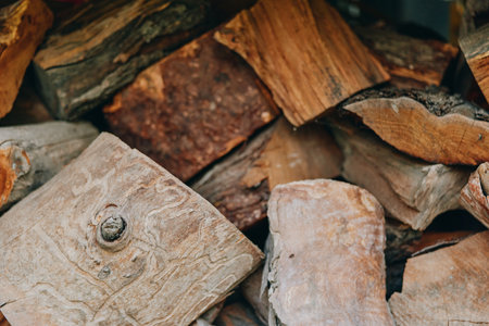 Firewood woodpile chopped logs stacked wood split logs timber in closeup, rustic backyard pile for fireplace and cabin heating, autumn cozy atmosphere with warm tones and natural texture.の写真素材