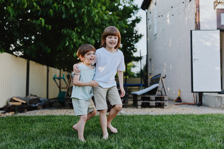 Happy children playing outdoors in a garden, enjoying the warm sunshine and a playful atmosphere. Their laughter fills the air as they bond and create memories.の写真素材