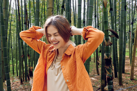 Woman smile bamboo forest outdoors nature portrait jacket, happy candid moment with eyes closed,...