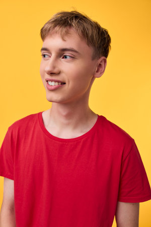 Young man in a red shirt stands against a bright yellow background, casual studio vibe, clean lighting, fashion style, approachable and friendly expression.の写真素材