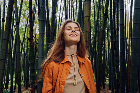 Woman smile bamboo forest nature portrait of a young woman with eyes closed, enjoying a serene outdoor moment in a green grove, peaceful relaxation, natural beauty and calm.の写真素材
