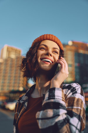 Woman on phone smile in urban street at golden hour, candid authenticity and emotional storytelling vibe, mindful living portrait with warm glow and modern city lifestyle.の写真素材