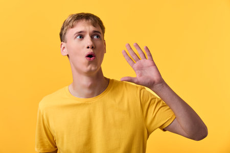 Shouting man in a yellow tee against a vivid background, capturing energy, gesture and expression for attention grabbing marketing visuals, ideal for campaign branding, product releases, and socialの写真素材