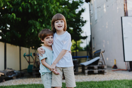 Happy children play together in a sunny backyard, showcasing friendship and joy in a natural setting, perfect for family-oriented themes.の写真素材