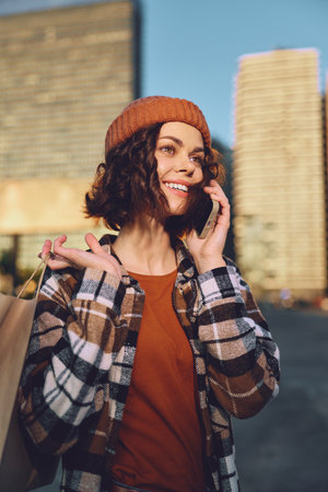 woman smile shopping phone urban candid authenticity captured in a golden hour glow; young female enjoying mindful living and candid lifestyle, emotional storytelling in a warm city street.の写真素材