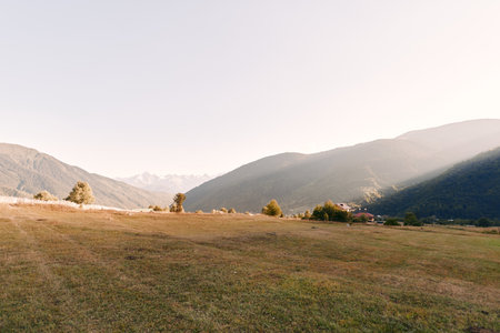 Meadow valley mountains grass landscape hills countryside rural scenery with open field, scattered...
