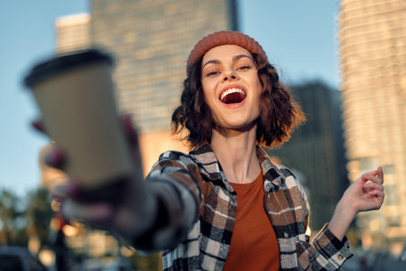 Woman coffee smile city candid golden lifestyle joyful portrait at golden hour with authenticity, mindful living and emotional storytelling; warm sunlight, casual beret and genuine laughter moment.の写真素材