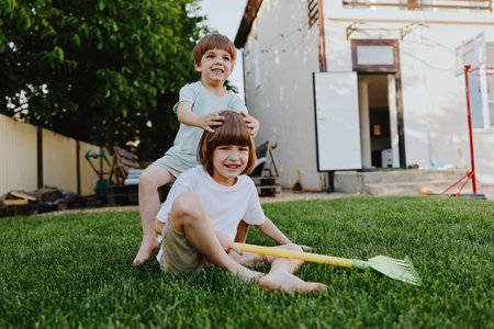 Happy children playing in a backyard, enjoying summer activities with toys and laughter. A joyful moment full of childhood innocence and fun.の写真素材