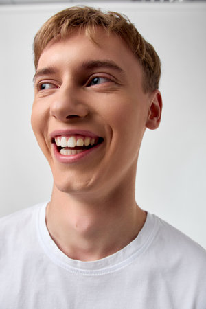Smiling man in a white shirt with a bright joyful expression, candid shot capturing happiness,...