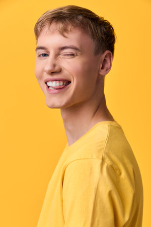 Smile and bright mood with a happy vibe, an individual wearing a yellow shirt against a yellow...