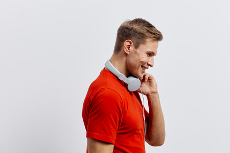 smiling man with headphones red t-shirt thinking side view isolated white background digital detox mental health conceptの写真素材