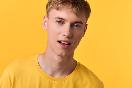 Yellow tee clad young man against bright yellow background, casual fashion vibe for lifestyle and...