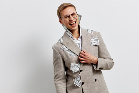 Smiling woman wearing glasses and beige blazer, cheerful and confident, standing against plain white wall, studio portrait. People lifestyle conceptの写真素材