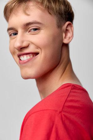 Smiling man in a red shirt, close up shot emphasizing a warm expression, casual style and confident vibe for lifestyle, positivity, and branding imageryの写真素材