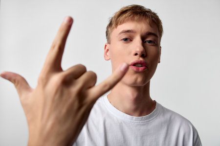 Hand gesture, rock on, young man, white t shirt, facial expression, confidence, attitude, lifestyle....