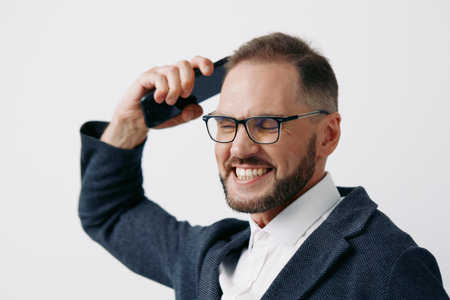 Professional business man on a call, smiling with confidence in a sharp blazer. The isolated colored background enhances his executive presence and energetic focus for corporate use.の写真素材
