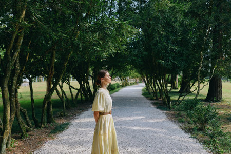 Woman in yellow dress on tree path authentic inclusive