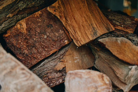 Firewood chopped wood stacked logs woodpile bark texture kindling: closeup of split oak and seasoned...
