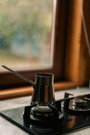 Coffee pot on gas stovetop by windowの写真素材