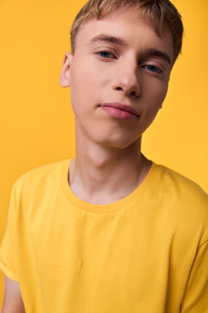 Man in a bright yellow shirt, close up studio headshot showcasing casual fashion with a confident youth look against a vivid backdrop, with vibrant moodの写真素材