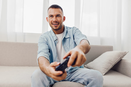 Engaging man enjoying a digital detox, relaxed on a couch, smiling and unwinding from technology's...