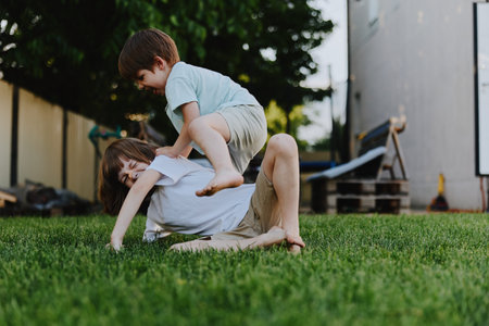 Playful children enjoying outdoor fun, depicting a joyful moment of friendship and laughter in a sunny garden setting, capturing childhood innocence and energy.の写真素材