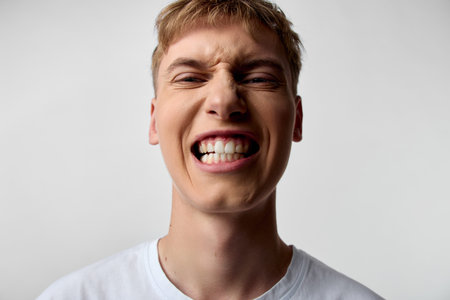 Smile, face, grin and teeth showcase a bold expression in a closeup of a male with a tight jaw and...