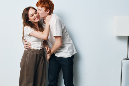 Couple, embrace and kiss with love and happiness in casual clothes at home interior. Young man and...