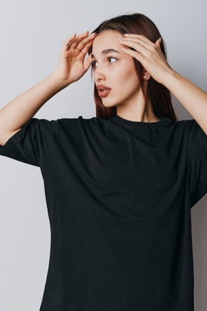 Young woman with long hair wearing black shirt touching forehead looking to side with thoughtful...