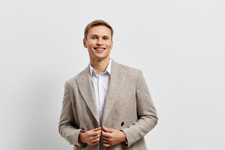 Smiling man digital nomad wearing beige checkered jacket white shirt hold smartphone isolated on white background work remotely conceptの写真素材