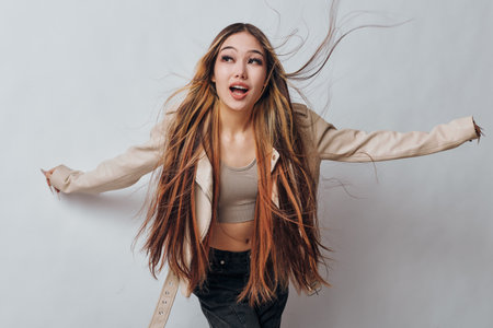 Young woman with long straight hair wearing casual outfit posing with arms extended isolated on...