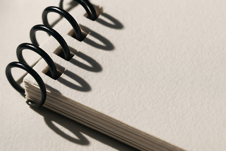 Close up of a spiral notebook on white background. Shallow depth of field.の素材