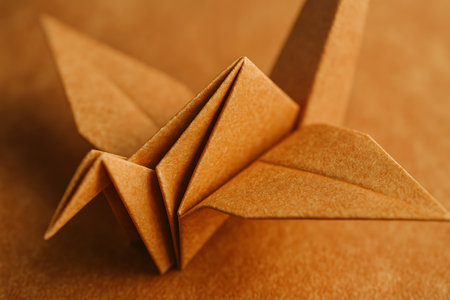 Paper origami bird on a brown background. Shallow depth of fieldの素材