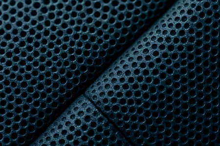 Close-up of blue perforated carbon fiber as background.の素材