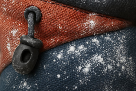 Close-up of a carabiner with snow on it.の素材