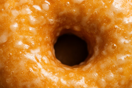 Close up of a donut with orange glaze. Whole background.の素材