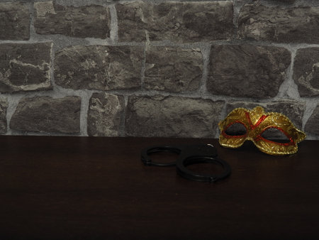 Waiting. Handcuffs and mask on the tableの写真素材