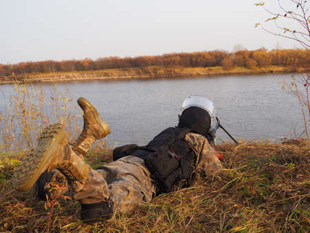 Machine gunner resting on the river Bank