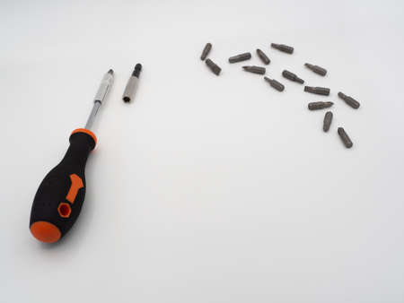 Screwdriver with scattered bits on a gray backgroundの写真素材