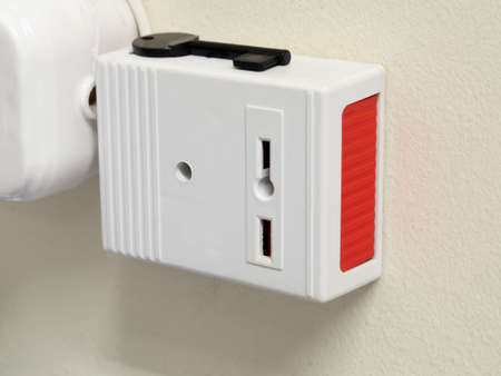 Security system. White and red alarm button with a black key on the background of a beige wall.の写真素材