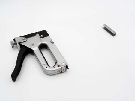 Old, rusty furniture stapler with one stack of staples on a light backgroundの写真素材