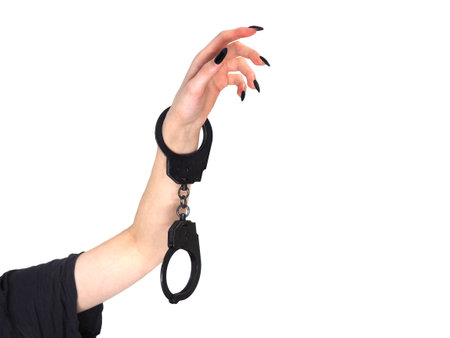 Female hand with police handcuffs isolated on white background. The concept of crime and punishment. Feminism, equality.の写真素材