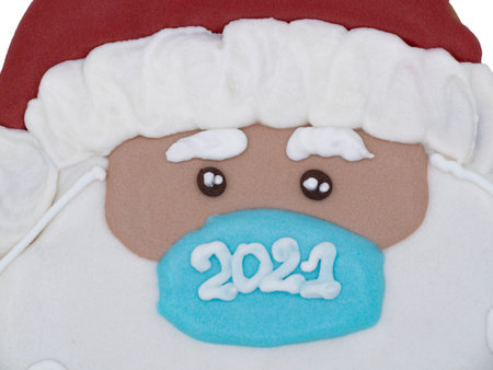 Christmas gingerbread on a white background. Santa Claus in a medical mask. Brown homemade cookies in colored icing sugar. New year ornament handmade decoration.の写真素材