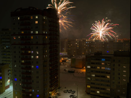 New Year or Christmas fireworks in the Russian suburbs. Composite photo of a color salute in the courtyard of a sleeping area of the city.の写真素材