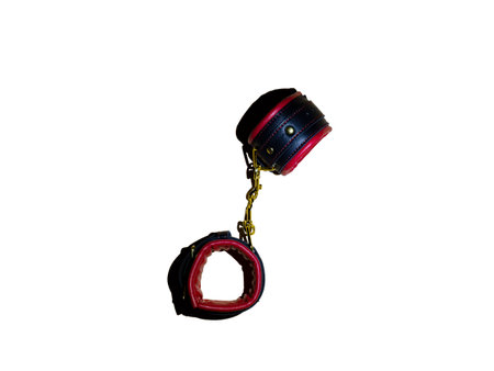 Toys for adults. Red and black leather handcuffs with gold-plated chain on white isolated background with shadow.  The concept of submission.の写真素材