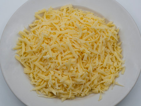 Large grated cheese in a white ceramic plateの写真素材