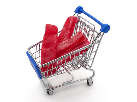 Dried fruits. Papaya candied red in a toy shopping trolley. The concept of affordable food, delicacies.の写真素材